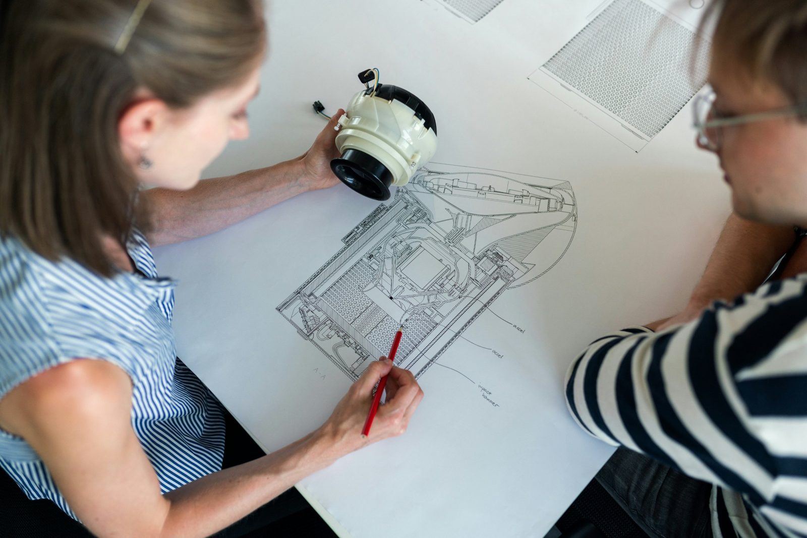 Due professionisti esaminano un disegno tecnico di un componente